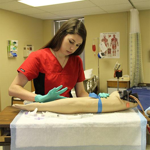 Nursing student practicing inserting an IV